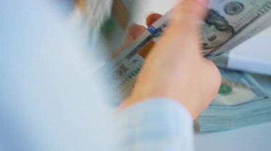 Amerikan dolarlarını sayan ya da nakit ödeyen eller. Yatırım, başarı, finansal beklentiler veya kariyer ilerlemesi kavramı