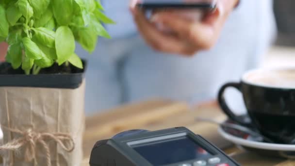 Kontaktloses Bezahlen mit dem Smartphone. Wireless Payment Konzept. Nahaufnahme: Frau nutzt Smartphone-NFC-Technologie für bargeldlosen Geldbeutel, um am Bankterminal zu bezahlen. — Stockvideo