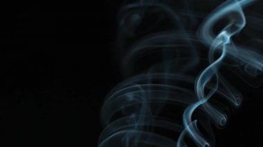 Soyut duman siyah arka planda güzel girdaplarda yükselir. Yavaş çekim