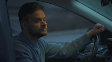 Adam arabada oturuyor, trafik kurallarını ihlal ettiği için polis tarafından durdurulduğu için üzgün.