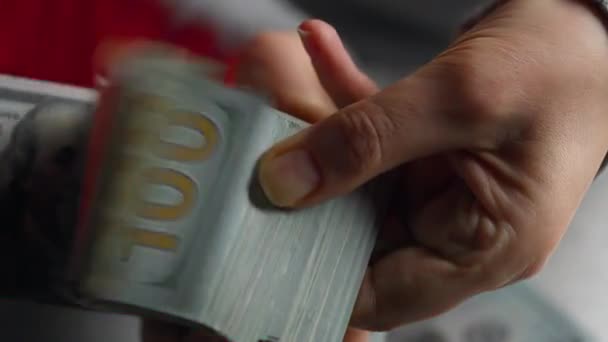 Руки, считая счета в долларах США или оплачивая наличными на фоне мигалок полицейских машин Стоковый Видеоролик