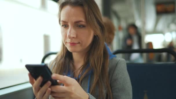 Mujer en tranvía usando el teléfono inteligente de chat y mensajes de texto con amigos. Ciudad, urbano, transporte. — Vídeo de stock