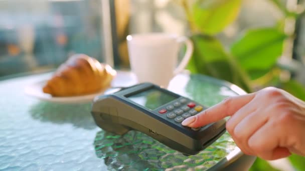 スマートフォンで非接触決済。ワイヤレス決済の概念。クローズアップ、カフェで銀行ターミナルで注文を支払うためにスマートフォンのキャッシュレス財布NFC技術を使用して女性. — ストック動画