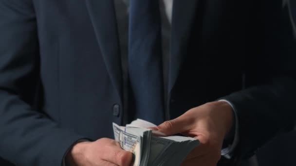 Bărbat îmbrăcat oficial numărând bancnotele de dolari americani. Conceptul de investiții, succes, perspective financiare sau avansare în carieră — Videoclip de stoc