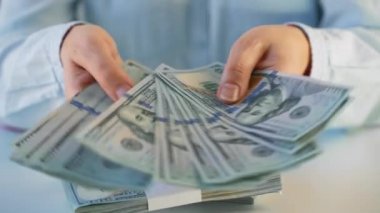 Amerikan dolarlarını sayan ya da nakit ödeyen eller. Yatırım, başarı, finansal beklentiler veya kariyer ilerlemesi kavramı