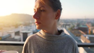 Kadın güne bir fincan çay ya da kahveyle başlıyor ve şafak vakti balkondaki akıllı telefonundaki e-postaları kontrol ediyor..