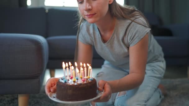 Vrouw blaast kaarsen uit op verjaardagstaart, viert alleen thuis haar verjaardag — Stockvideo