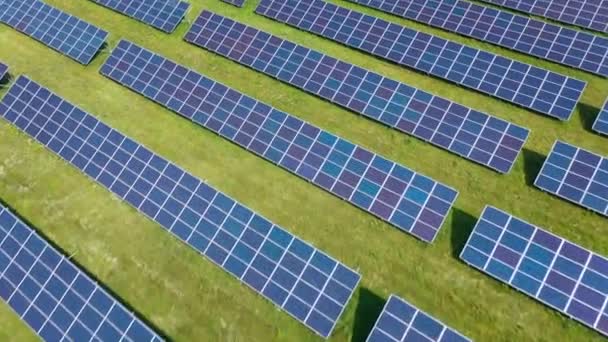 Vuelo sobre un campo de paneles solares en el soleado día de verano. Innovación ecológica. — Vídeo de stock