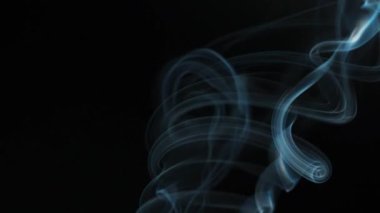 Soyut duman siyah arka planda güzel girdaplarda yükselir. Yavaş çekim
