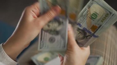 Amerikan dolarlarını sayan ya da nakit ödeyen eller. Yatırım, başarı, finansal beklentiler veya kariyer ilerlemesi kavramı