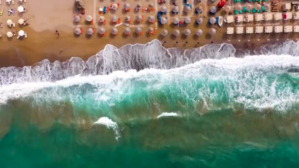 Deniz manzarası, kumlu plaj, güneş şemsiyeleri ve güneşlikler, tanınmayan insanlar. Yunanistan 'ın Girit kentinde güzel bir tatil ve turizm beldesi. — Stok video