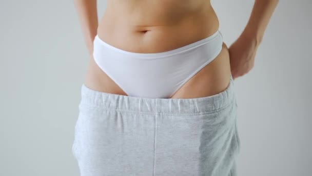 Vrouw trekt haar broek aan. Concept van gezonde spijsvertering. — Stockvideo