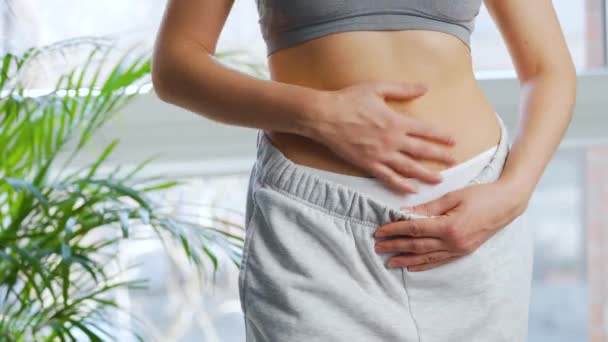La mujer se pone los pantalones, acaricia el estómago y levanta los pulgares. Concepto de digestión saludable y función intestinal. — Vídeo de stock