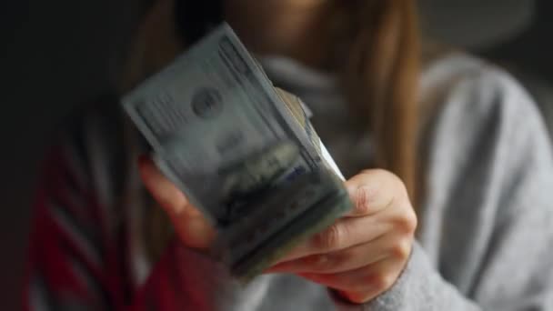 Mulher verifica notas de dólar dos EUA ou contando em dinheiro contra o pano de fundo das luzes do carro da polícia — Vídeo de Stock