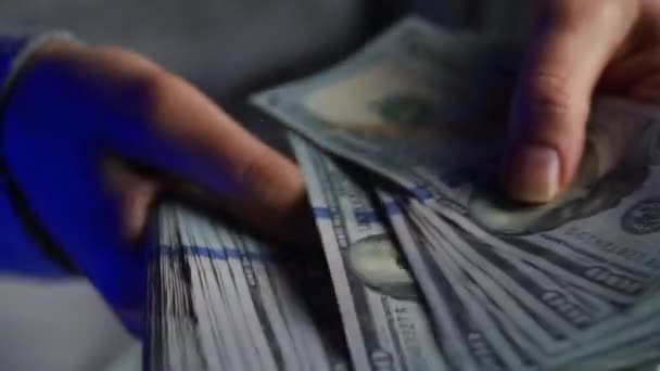 Руки проверяют счета в долларах США или подсчитывают наличными на фоне мигалок полицейских машин — стоковое видео