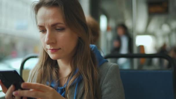 Frau in der Straßenbahn mit Smartphone im Chat und SMS mit Freunden. Stadt, Stadt, Verkehr. — Stockvideo