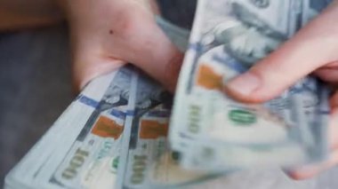 Amerikan dolarlarını sayan ya da nakit ödeyen eller. Yatırım, başarı, finansal beklentiler veya kariyer ilerlemesi kavramı