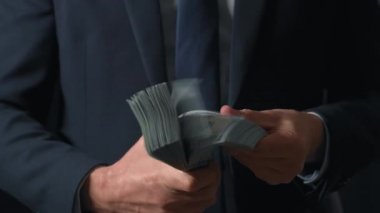 Resmi olarak giyinmiş adam Amerikan dolarlarını sayıyor. Yatırım, başarı, finansal beklentiler veya kariyer ilerlemesi kavramı