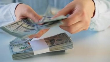 Amerikan dolarlarını sayan ya da nakit ödeyen eller. Yatırım, başarı, finansal beklentiler veya kariyer ilerlemesi kavramı