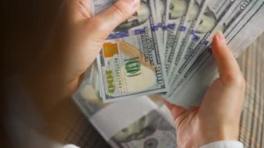 Amerikan dolarlarını sayan ya da nakit ödeyen eller. Yatırım, başarı, finansal beklentiler veya kariyer ilerlemesi kavramı