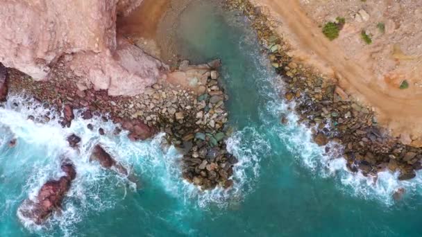 Blick von oben auf die Mittelmeerküste, Wellen erreichen die menschenleere Küste. Schönes Urlaubs- und Touristenziel in Griechenland. — Stockvideo