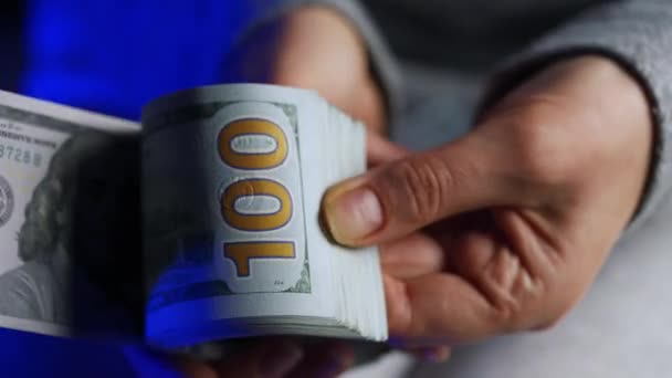 Handen controleert US Dollar rekeningen of tellen in contanten tegen de achtergrond van de politie auto lichten — Stockvideo