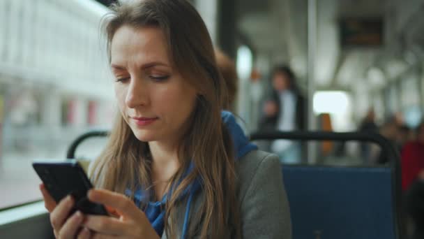 Mujer en tranvía usando el teléfono inteligente de chat y mensajes de texto con amigos. Ciudad, urbano, transporte. — Vídeo de stock