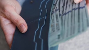 Kadın Amerikan dolarlarını sayıyor ve cüzdanına koyuyor..