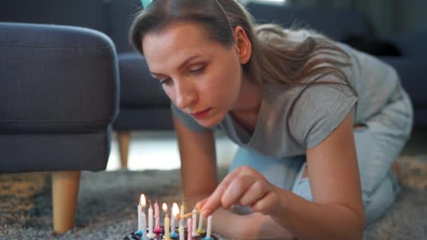 Mulher acendendo velas no bolo de aniversário, celebrando aniversário em casa sozinha — Vídeo de Stock