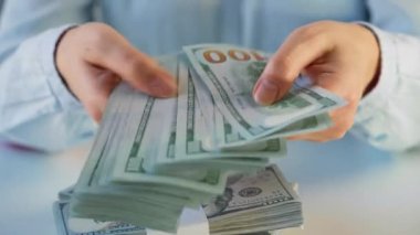Amerikan dolarlarını sayan ya da nakit ödeyen eller. Yatırım, başarı, finansal beklentiler veya kariyer ilerlemesi kavramı