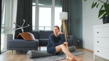 Kadın odanın ortasında derin düşüncelere dalmış oturuyor. Temizlenmesi gerekiyor, ama işi ağırdan alıyor. Yavaş çekim