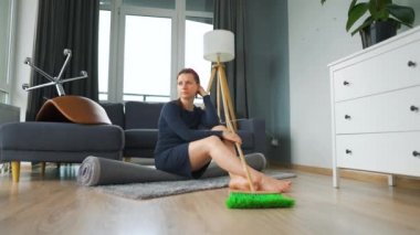 Kadın odanın ortasında derin düşüncelere dalmış oturuyor. Temizlenmesi gerekiyor, ama işi ağırdan alıyor. Yavaş çekim