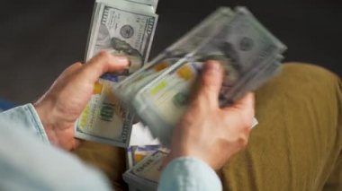 Erkek eller Amerikan dolarlarını sayıyor ya da nakit ödüyor. Yatırım, başarı, finansal beklentiler veya kariyer gelişimi kavramı. Aşırı yakın çekim