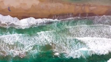 Deniz manzarası, kumlu plaj, güneş şemsiyeleri ve güneş yatakları, tanınmayan insanlar. Yunanistan 'ın Girit kentinde güzel bir tatil ve turizm beldesi.