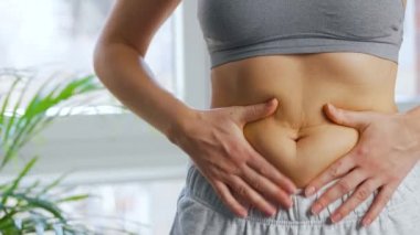 Kadın derisini karnına ve yanlarına bastırıp deri altında fazla yağ var mı diye kontrol ediyor. Genel kabul görmüş güzellik standartlarını karşılamaya çalışma kavramı