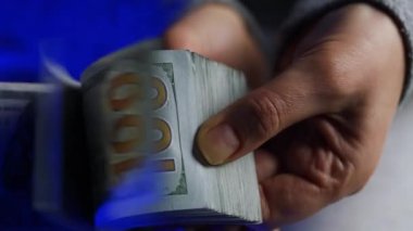 Kadın elleri Amerikan Doları 'nı kontrol ediyor ya da polis arabasının arka planında nakit para sayıyor. Yolsuzluk, rüşvet ve mali suçlar kavramı.