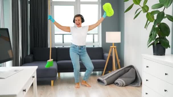 Λευκή Γυναίκα Ακουστικά Που Καθαρίζει Σπίτι Και Διασκεδάζει Χορεύοντας Σκούπα — Αρχείο Βίντεο