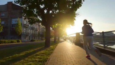 Kadın şafak vakti sette koşuyor. FPV insansız hava aracı çekiliyor. Terk edilmiş sokaklar boyunca bir kadının yanından uçarak geçmek.