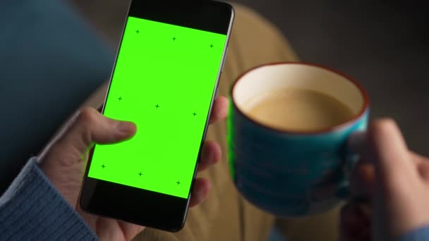 Mann Benutzt Smartphone Mit Grünem Bildschirm Vertikalen Modus Und Trinkt — Stockvideo