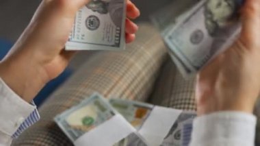 Amerikan dolarlarını sayan ya da nakit ödeyen bir kadın. Yatırım, başarı, finansal beklentiler veya kariyer ilerlemesi kavramı