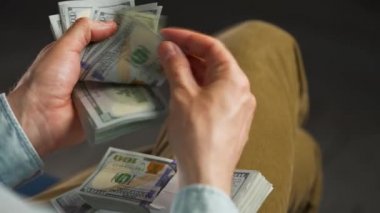 Erkek eller Amerikan dolarlarını sayıyor ya da nakit ödüyor. Yatırım, başarı, finansal beklentiler veya kariyer gelişimi kavramı. Aşırı yakın çekim