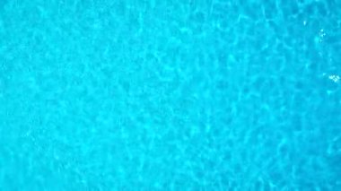 Yüzme havuzundaki saf mavi suyun yüzeyinde ışık yansımaları var. Hava görüntüleri