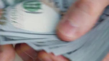 Erkek eller Amerikan dolarlarını sayıyor ya da nakit ödüyor. Yatırım, başarı, finansal beklentiler veya kariyer gelişimi kavramı. Aşırı yakın çekim