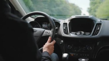 Adam yağmur yağarken yolda araba sürüyor. Sürücülerin omzunun arkasından bak.