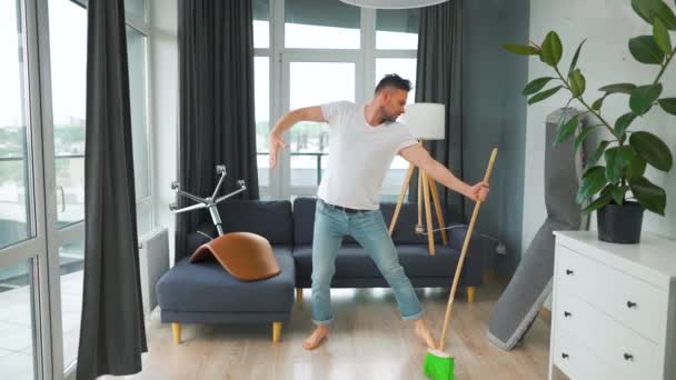 Pria Kaukasia Membersihkan Rumah Dan Bersenang Senang Menari Dengan Sapu — Stok Video