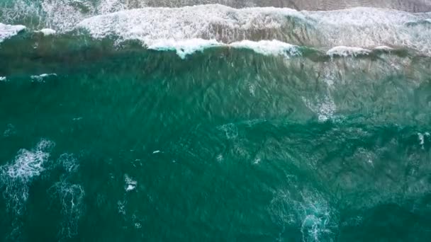砂浜の海岸線で波が砕けている間 美しいシームレスな終わりのない映像のドローンビュー 地中海沿岸のトップビューは 波が無人の砂浜に到達します 美しい — ストック動画