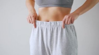 Woman puts on her pants. Concept of good health, healthy digestion and bowel function