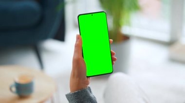 Evde dikey modda yeşil ekranlı akıllı telefon kullanan bir kadın var. İnternette gezinen, içerik izleyen, videolar, bloglar. POV