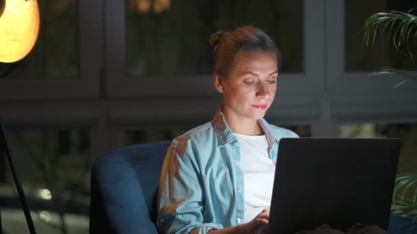 Жінка Сидить Кріслі Працює Ноутбуці Вночі Або Комусь Пише Концепція — стокове відео