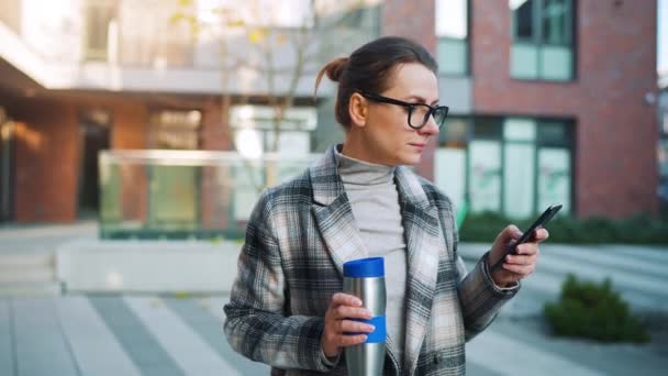 Caucasian Businesswoman Glasses Coat Walks Business District Drinking Coffee Using — Stock Video